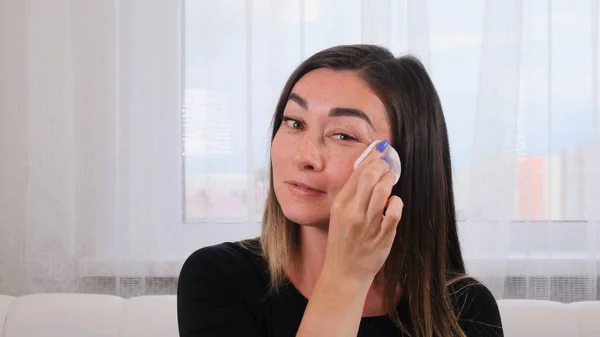 Femme nettoie sa peau parfaite avec une éponge avec un coton blanc. La jeune femme prend soin de son visage. Spa et bien-être, concept de soins de la peau. Soins personnels — Photo