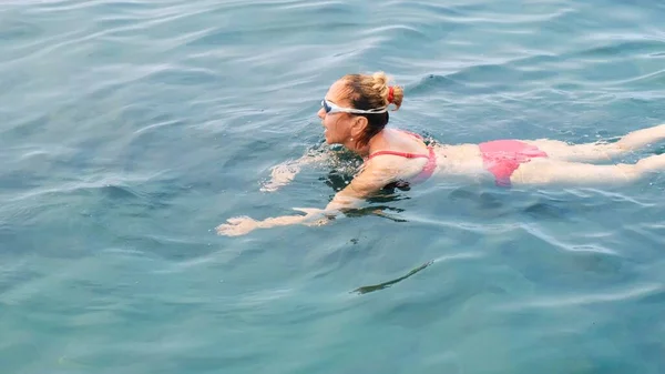 Femmina in occhiali sta praticando strisciare nuotando nel mare. Nuotatore professionista, gara di nuoto. Nuotatore anteriore strisciante. Lezioni di nuoto. — Foto Stock