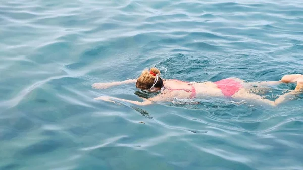 50-55-60 éves nő, szemüvegben, vonattal mászik a tengerbe. Profi úszó, úszóverseny. Elöl úszik. Úszóórák. — Stock Fotó