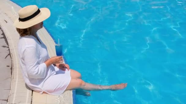 Seniorin entspannt sich im Hotelschwimmbecken. Die Menschen genießen ihren Sommerurlaub. All inclusive — Stockvideo