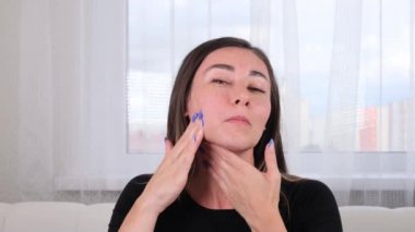 Güzel esmer kadın masaj çizgileri boyunca kendine bir yüz masajı yapıyor ve elleriyle işaret ediyor. Yüz masajı. Yüz jimnastiği. Egzersiz sistemi cildinizi geliştirir