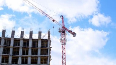 İkametgah inşaat endüstrisi. Bir apartman dairesinin inşasına eşit katılım. İpotek. Bina yapım aşamasında ve gökyüzünün arka planında bir vinç