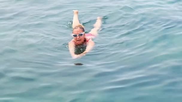 Female senora in glasses is practicing crawl swimming in the sea. Professional swimmer, swimming race. Front crawl swimmer. Swimming lessons. — Stock Video