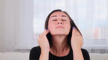 Güzel esmer kadın masaj çizgileri boyunca kendine bir yüz masajı yapıyor ve elleriyle işaret ediyor. Yüz masajı. Yüz jimnastiği. Egzersiz sistemi cildinizi geliştirir