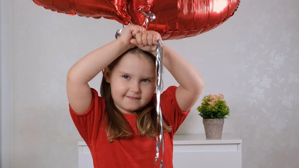 Lustiges kleines Mädchen mit drei herzförmigen Luftballons zum Valentinstag. Familienliebe. Geschenke für den Urlaub. Glück und Küsse — Stockfoto