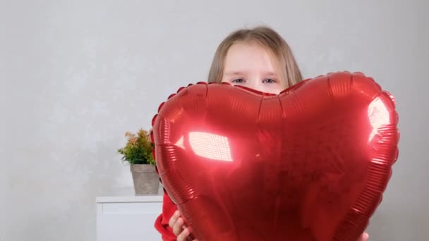 Pretty cute girl holding heart shaped crane balloons on valentines day. — Wideo stockowe