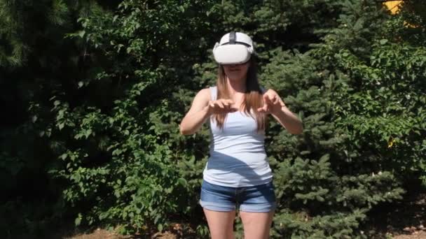 Female in virtual reality glasses on the background of the forest. getting experience using VR headset glasses of virtual reality — Stockvideo