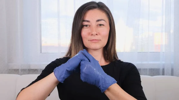 Perempuan dalam sarung tangan pelindung biru menggunakan pembersih tangan gel desinfektan untuk mencegah wabah virus atau agen antibakteri. — Stok Foto
