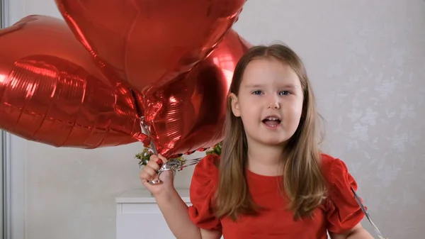 Drôle de petite fille avec trois ballons en forme de coeur pour la Saint-Valentin. amour de famille. cadeaux pour les vacances. bonheur et baisers — Photo