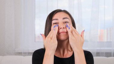 Beyaz kadın masaj çizgileri boyunca yüz masajı yapıyor ve ellerle puan topluyor. Yüz masajı. Hijyen, güzellik uzmanı, makyaj. Yüz jimnastiği. Egzersiz sistemi cildinizi geliştirir