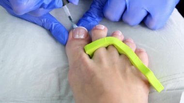 Pedikür güzellik salonu. Tırnak cilasıyla oje sürmek. Fransız. Kapat..