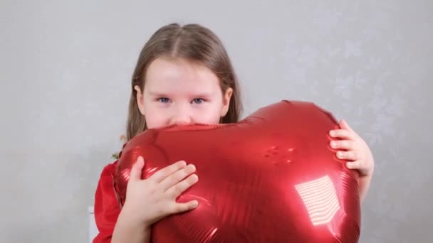 Menina muito bonito segurando coração em forma de balões guindaste no dia dos namorados. — Vídeo de Stock
