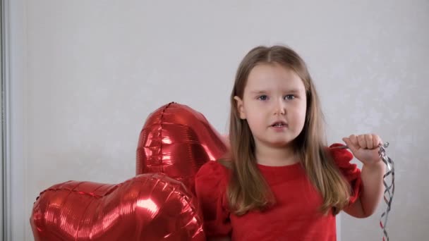 Funny little girl with three heart shaped balloons for valentines day. family love. gifts for the holiday. happiness and kisses — Wideo stockowe
