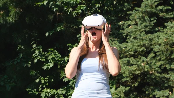 Rädd kvinna i virtual reality glasögon skriker av skräck från rädslan för vad han såg på skärmen av enheten — Stockfoto