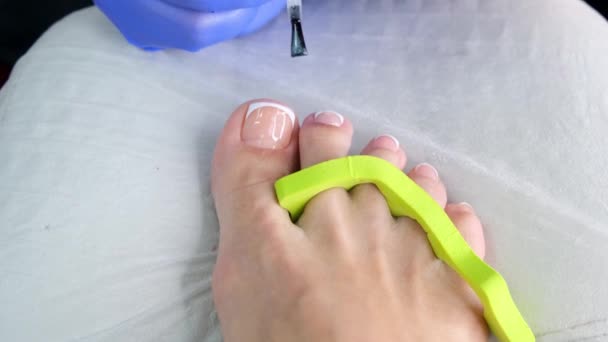 Salão de beleza de pedicure. Polimento de unhas com esmalte. Francês. de perto. — Vídeo de Stock