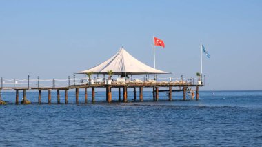 Türkiye 'de Akdeniz kıyısındaki popüler turistik tatil beldesinde küçük ahşap iskele ve deniz suyu