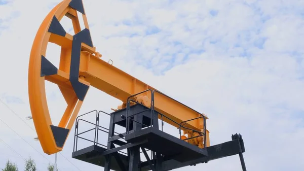 Industrieel landschap. olieveld. Oliepompen tegen de blauwe lucht. Het concept van olieproductie, verwerking van grondstoffen, verkoop en kosten van een vat olie. — Stockfoto