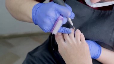 Güzellik salonunda Pedikür Spa prosedürü. Ayak soyma. Pedikür için elektrikli aparat. Yakın çekim, seçici odak.