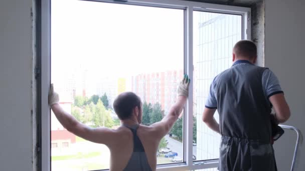 Demontage und Montage eines Fensters in einer Wohnung durch zwei Arbeiter: Moskau, Russland - 17. August 2021. — Stockvideo