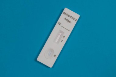 Negatif SARS-CoV-2 Hızlı Antijen Testi mavi arka planda burun çubuğuyla izole edildi