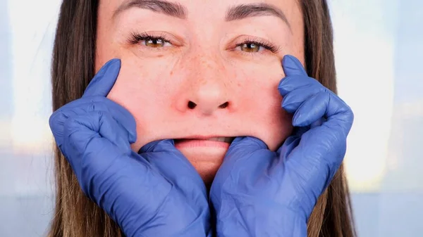 Cosmetóloga doctora mujer da masaje facial bucal a sí misma, enseñando y mostrando masaje neuromuscular intraoral, de cerca —  Fotos de Stock