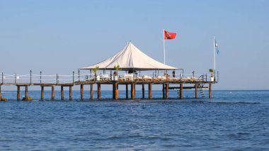 Türkiye 'de Akdeniz kıyısındaki popüler turistik tatil beldesinde küçük ahşap iskele ve deniz suyu