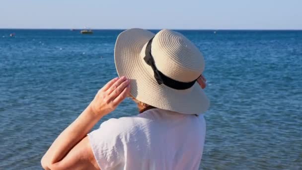 Schöne 50-jährige Frau mit Strohhut und Sonnenbrille auf blauem Meeresgrund. Sommer, Urlaub, Urlaub, aktive Rentner — Stockvideo