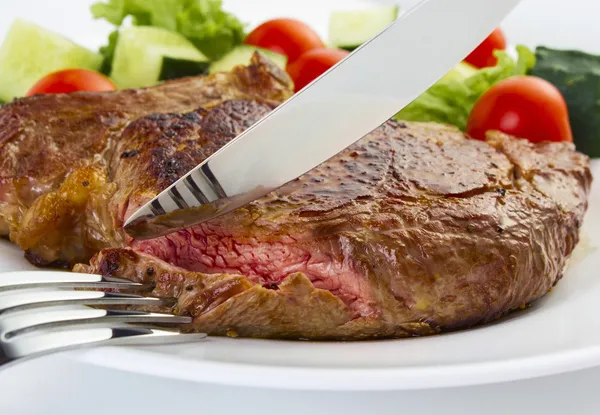 Juicy steak with fork and knife — Stock Photo, Image