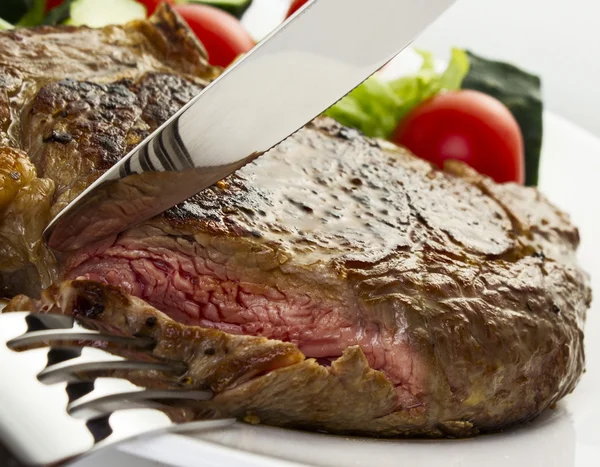 Juicy steak with fork and knife — Stock Photo, Image