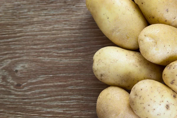 Potatoes on wood background — Stock Photo, Image