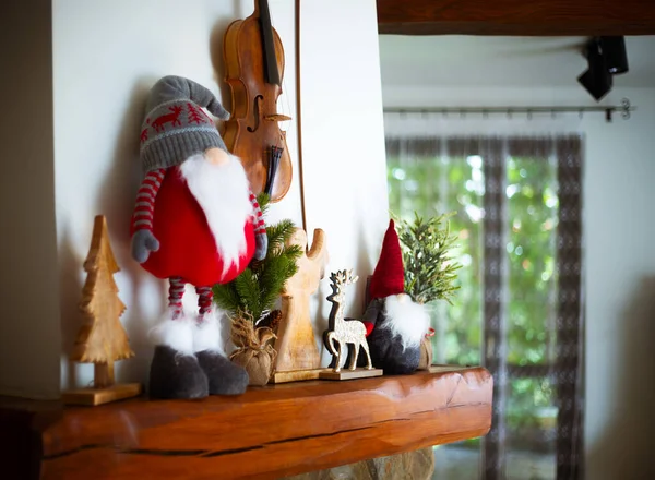 用圣诞装饰品装饰的壁炉上的小提琴 — 图库照片