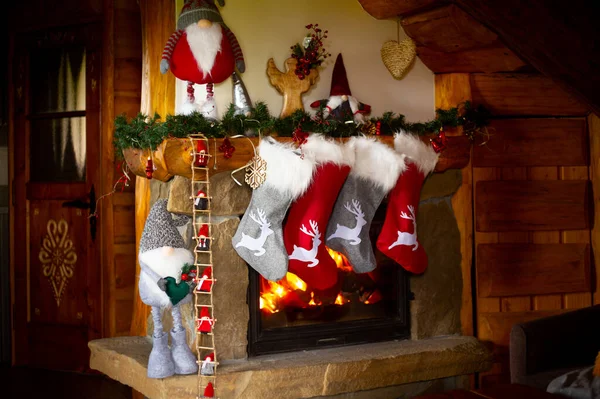 圣诞袜挂在燃烧的壁炉上的照片 — 图库照片