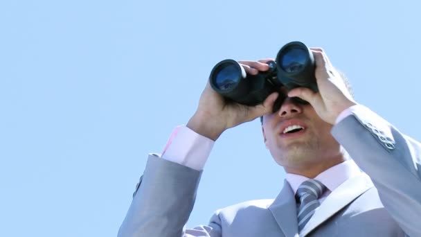 Young businessman looking through binoculars — Stock Video