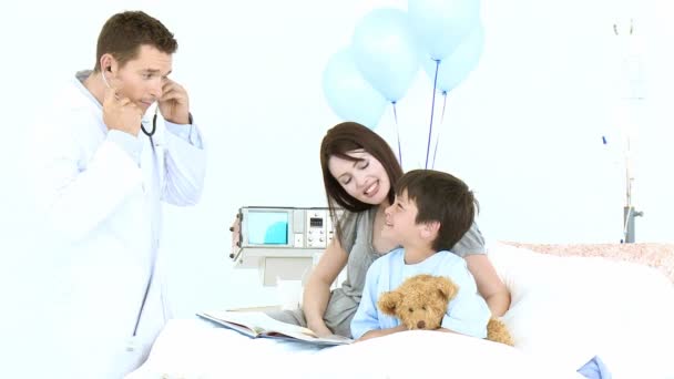 Doctor listening with a stethoscope to a teddy bear — Stock Video