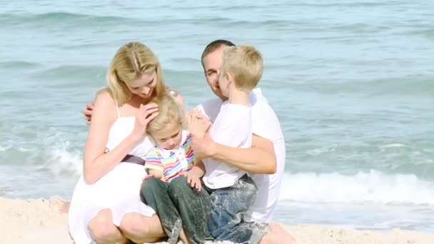 Familia sentada en la playa — Vídeos de Stock