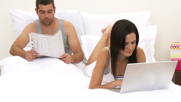 Man en vrouw in bed met behulp van een laptop — Stockvideo