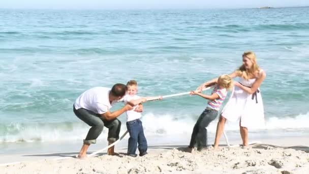 Eltern und Kinder spielen mit einer Schnur am Strand — Stockvideo