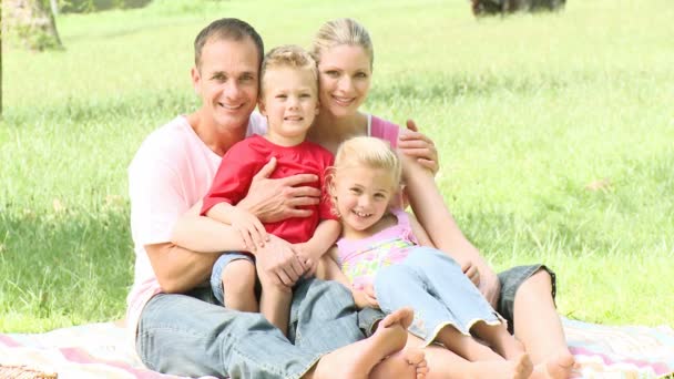 Famille assise dans un parc — Video