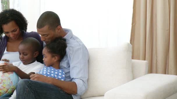 Panorama de la joven familia afroamericana sosteniendo un globo terrestre — Vídeos de Stock