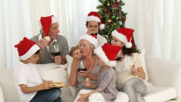 Familia feliz bebiendo vino y comiendo dulces en Navidad — Vídeos de Stock