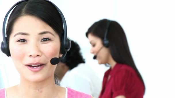 Close-up van Aziatische vrouw die werkt in een callcenter — Stockvideo