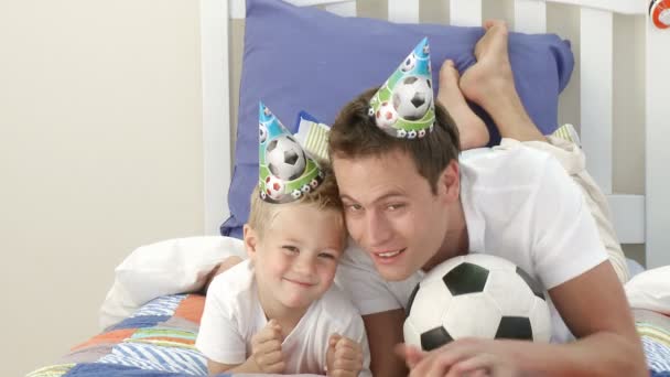 お父さんと男の子の寝室で、サッカー観戦をしたり — ストック動画