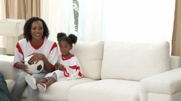 Afro-American family watching a football match at home — Stock Video