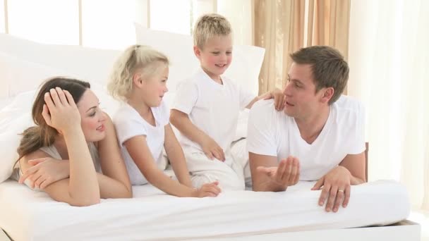 Feliz jovem família brincando na cama — Vídeo de Stock