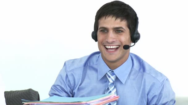 Homem de negócios sorrindo falando em um fone de ouvido em um call center — Vídeo de Stock