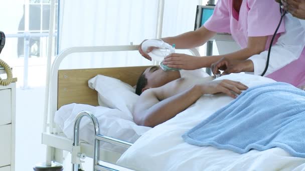 Врач и медсестра осматривают пациента в постели — стоковое видео