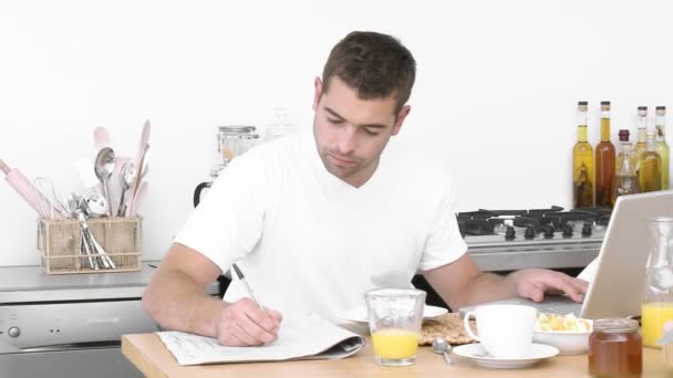 Человек, работающий с ноутбуком на кухне — стоковое видео