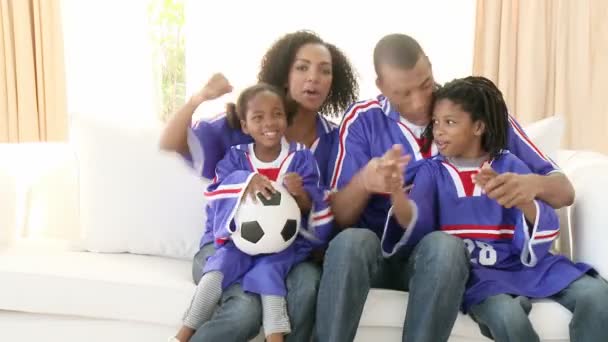 Afro-American familj tittar på en fotbollsmatch hemma — Stockvideo