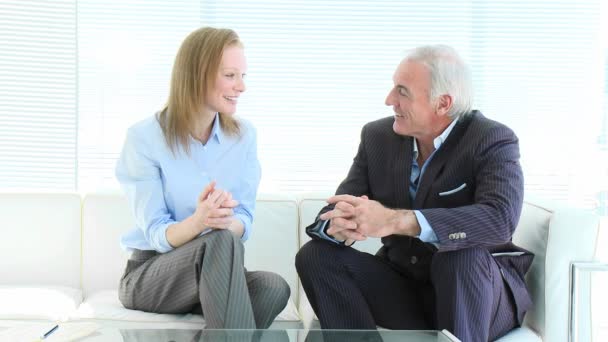 Empresaria y empresario senior hablando en un sofá — Vídeos de Stock