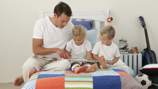 Padre leyendo con sus hijos en el dormitorio — Vídeos de Stock